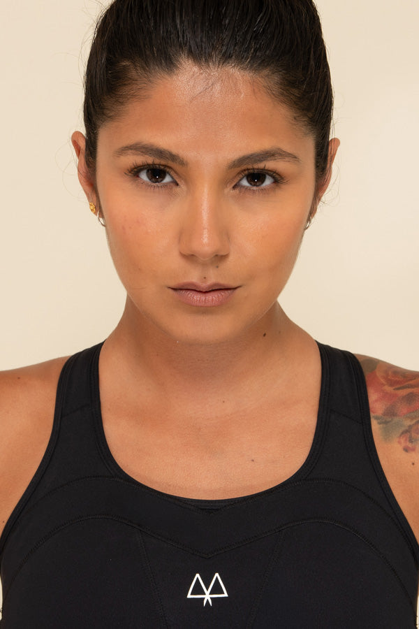 Close up of a Woman wearing a Black Sports Bra. The Overband Technology and white MAAREE logo is in focus.